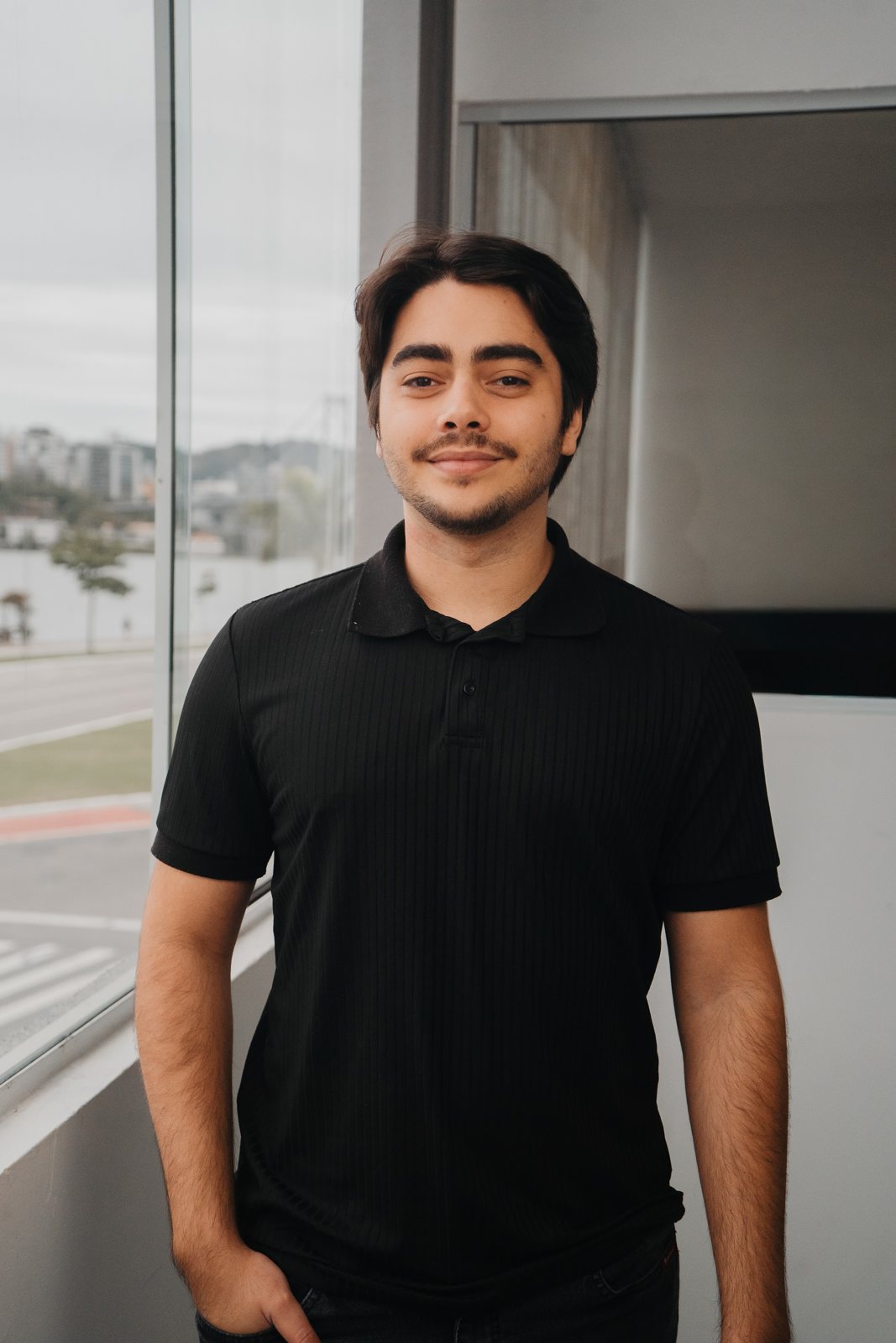 Julio Lossavaro em pé no escritório, sorrindo